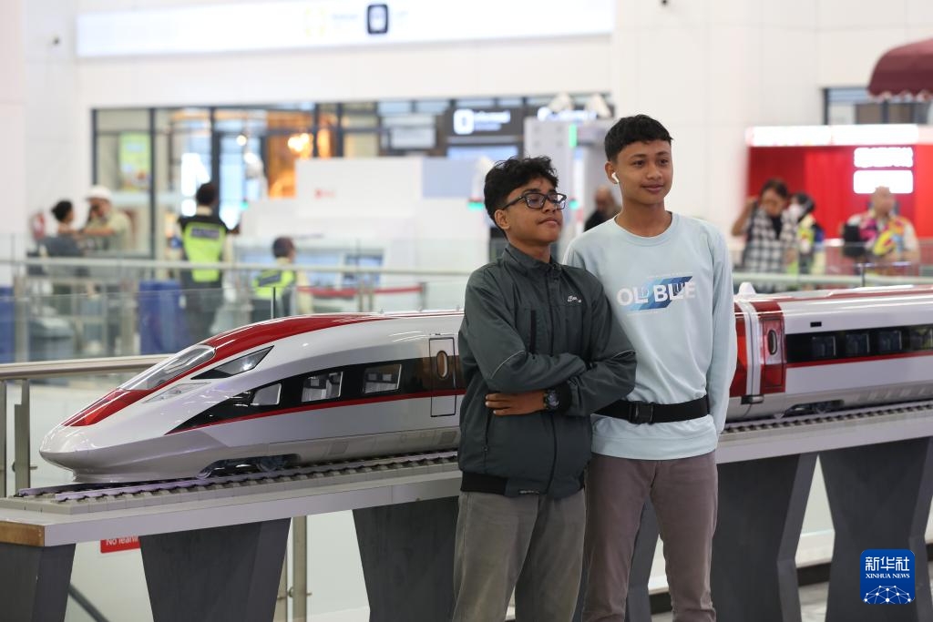 Ngày 19 tháng 6, tại nhà ga Halim (thủ đô Jakarta, Indonesia), hai hành khách chụp ảnh với mô hình đoàn tàu cao tốc Jakarta - Bandung trong sảnh chờ.  Ảnh: Sầm Vân Bằng - Phóng viên Tân Hoa xã