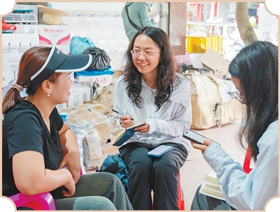Phóng viên Báo này phỏng vấn các thương hộ Việt Nam (Tả Nhất) kinh doanh hoa quả tại Na Pha. Ảnh: Nghiêm Lập Chính – phóng viên Nhân Dân nhật báo điện tử