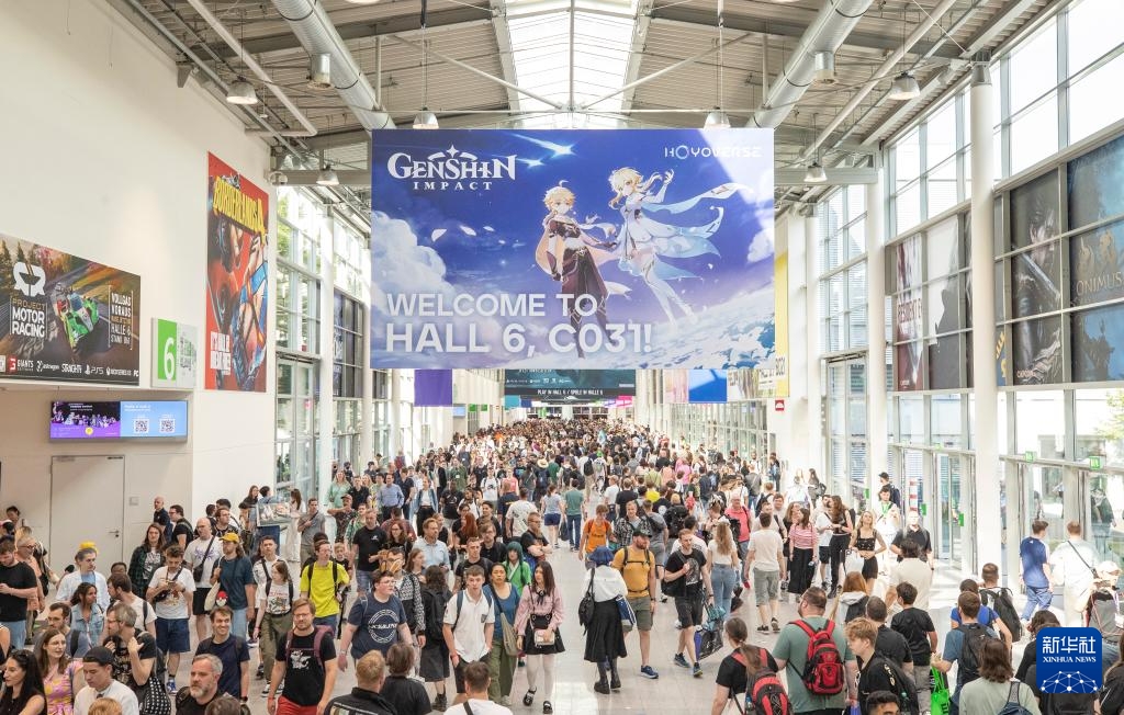 Ngày 21 tháng 8, khách tham quan đi ngang qua poster game Nguyên Thần (Genshin Impact) tại Gamescom Cologne, Đức. Ảnh: Trương Phàm – Phóng viên Tân Hoa xã