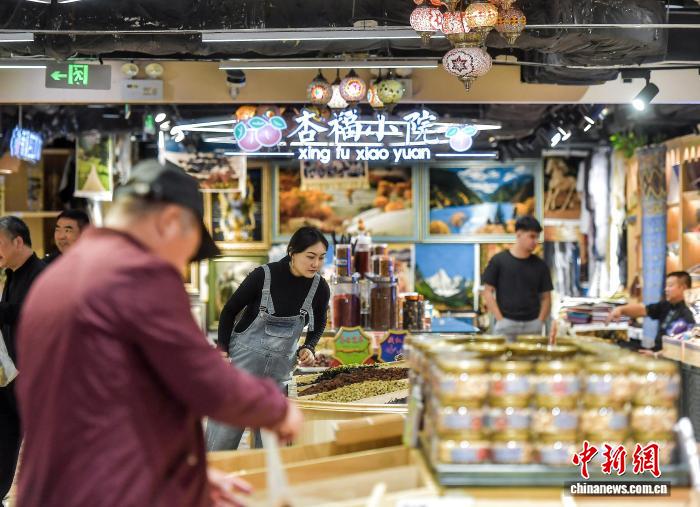 Ngày 22 tháng 9, khách du lịch chọn mua các loại quả khô tại phố đi bộ Đại Ba Trát ở thành phố Urumqi, Tân Cương, Trung Quốc.Ảnh: Lưu Tân - Phóng viên Chinanews