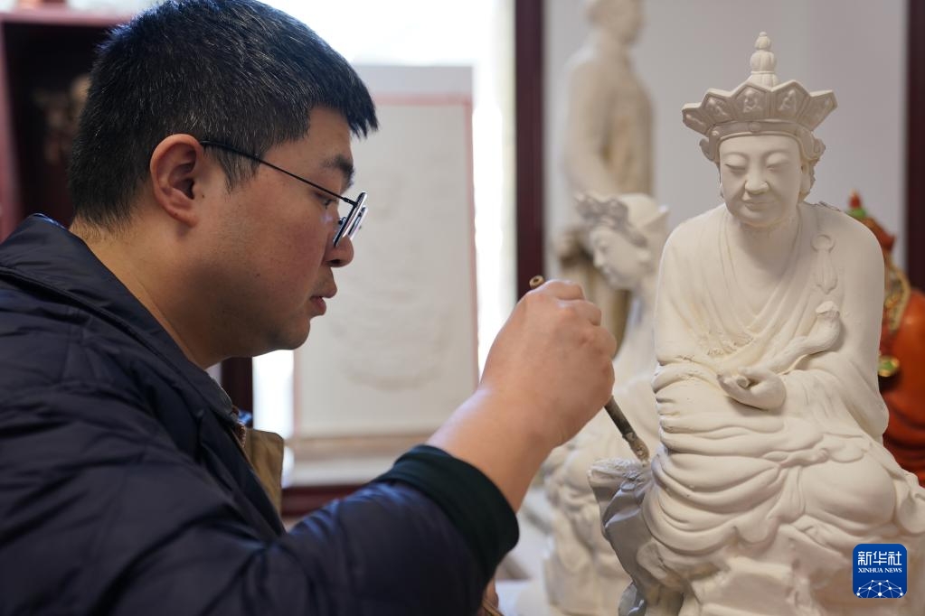 Ngày 12/3, Tăng Duệ chỉnh sửa tác phẩm sao chép của tượng “Phật cạn lời”.Ảnh: Chu Mật - Phóng viên Tân Hoa Xã