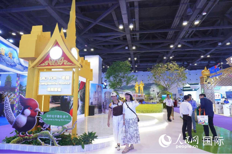 Du khách chụp ảnh check-in trước khu triển lãm “Thành phố hấp dẫn” của Lào. Ảnh: Dương Xuân Yến – Nhân Dân nhật báo điện tử